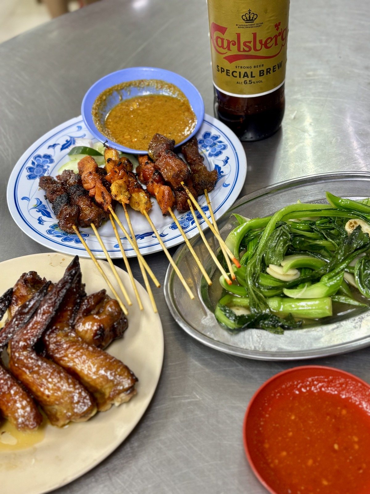 Wong Ah Wahのテーブル。焼き手羽先、サテ、青菜のにんにく炒め、Carlsberg Special Brew
