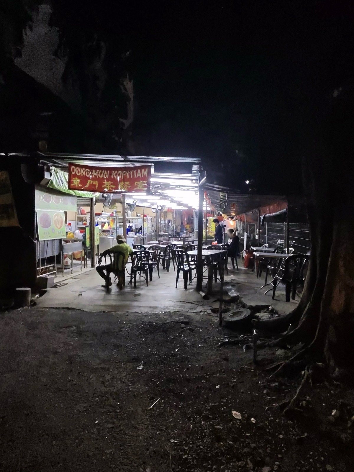 DONG MUN KOPITIAM 東門茶餐室の看板と、蛍光灯の下のテーブル席