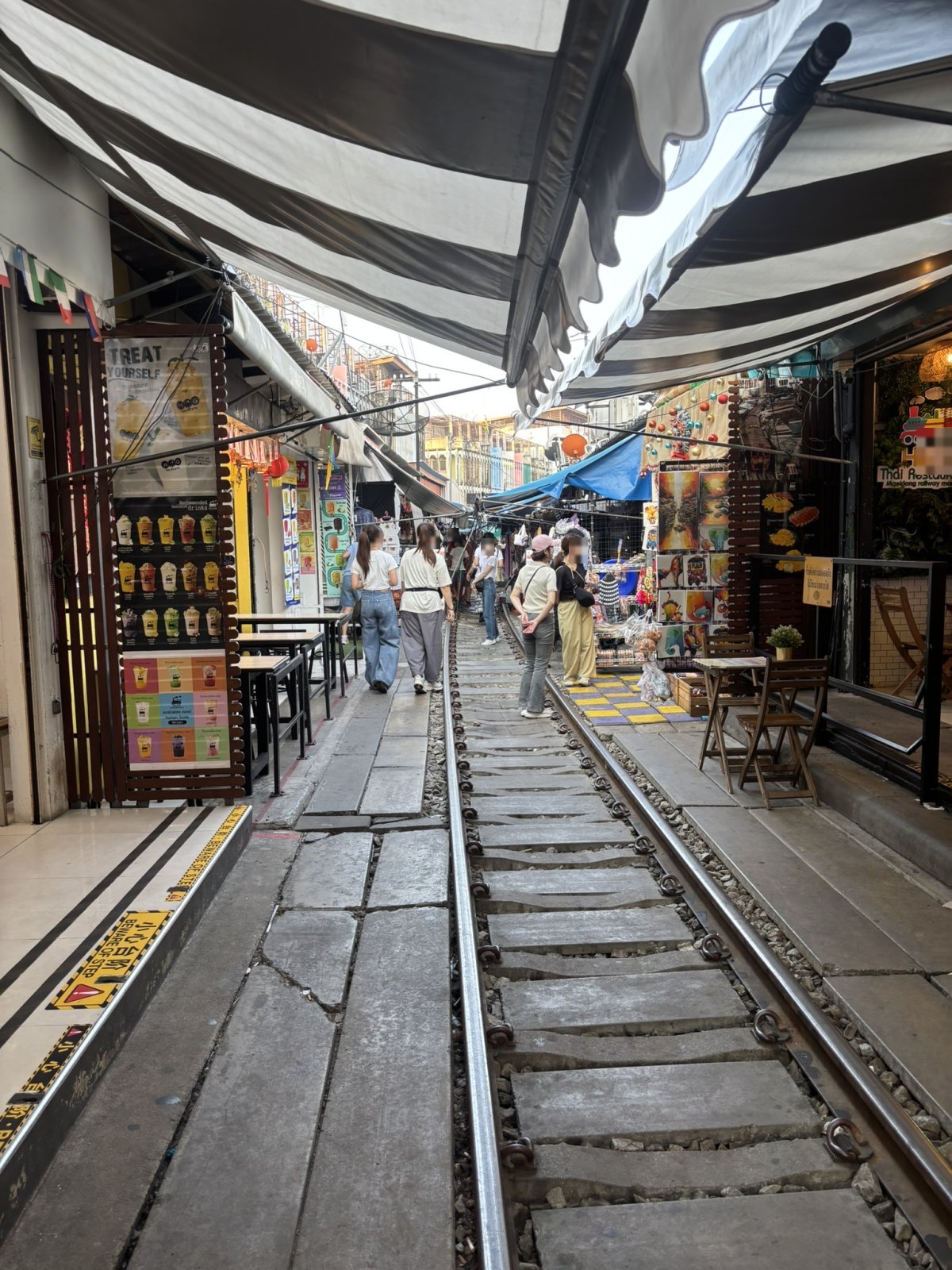 両脇に店が並ぶメークロン線路市場の線路の通路
