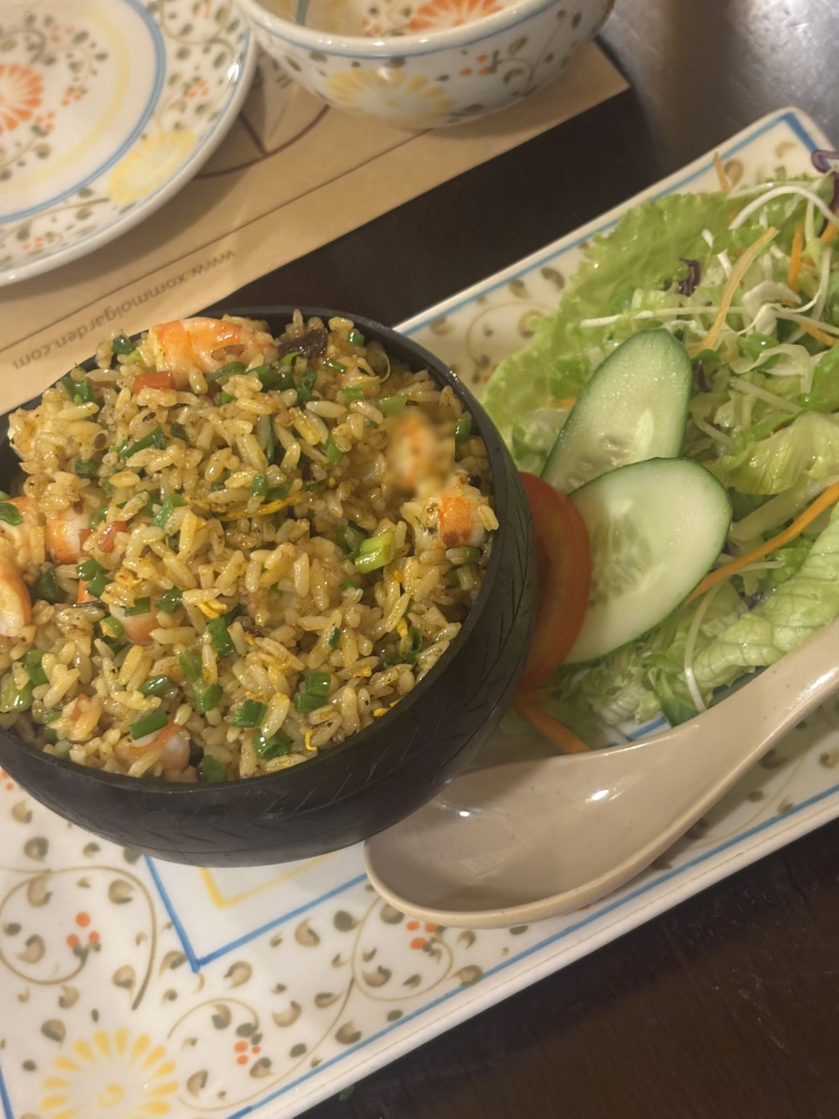 菊柄の皿に盛られたシーフード炒飯